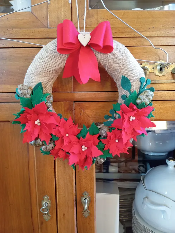 Ghirlanda fuori porta natalizia con stelle di Natale rosse